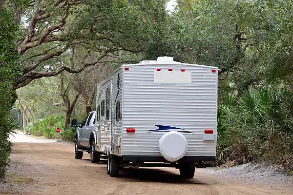 Vehicle towing an RV behind it on a country road